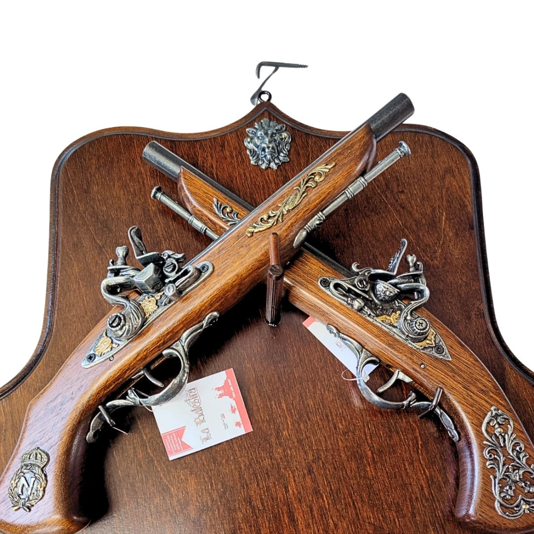 Réplica de pistolas de pederneira em suporte de madeira com possibilidade de personalização por gravação – Elemento decorativo elegante para presente a amantes de história – Dimensões 45 x 42,5 cm, comprimento das pistolas 37 cm, alta qualidade de fabrico