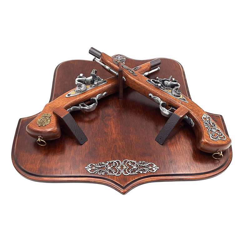 Réplica de pistolas de pederneira em suporte de madeira com possibilidade de personalização por gravação – Elemento decorativo elegante para presente a amantes de história – Dimensões 45 x 42,5 cm, comprimento das pistolas 37 cm, alta qualidade de fabrico